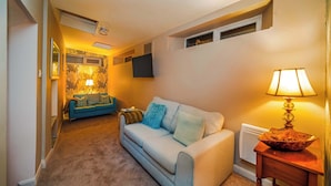 A cozy living room with a sofa, a lamp, and a decorative bowl on a side table.