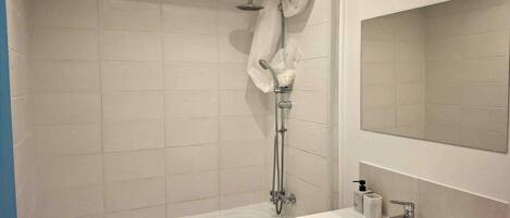 A modern bathroom with a bathtub, a shower, and a sink with a mirror.