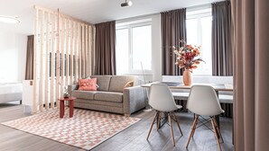 A modern living room with a sofa, coffee table, and dining area. - Lebe'schlitters - Im Zillertal (Schlitters)