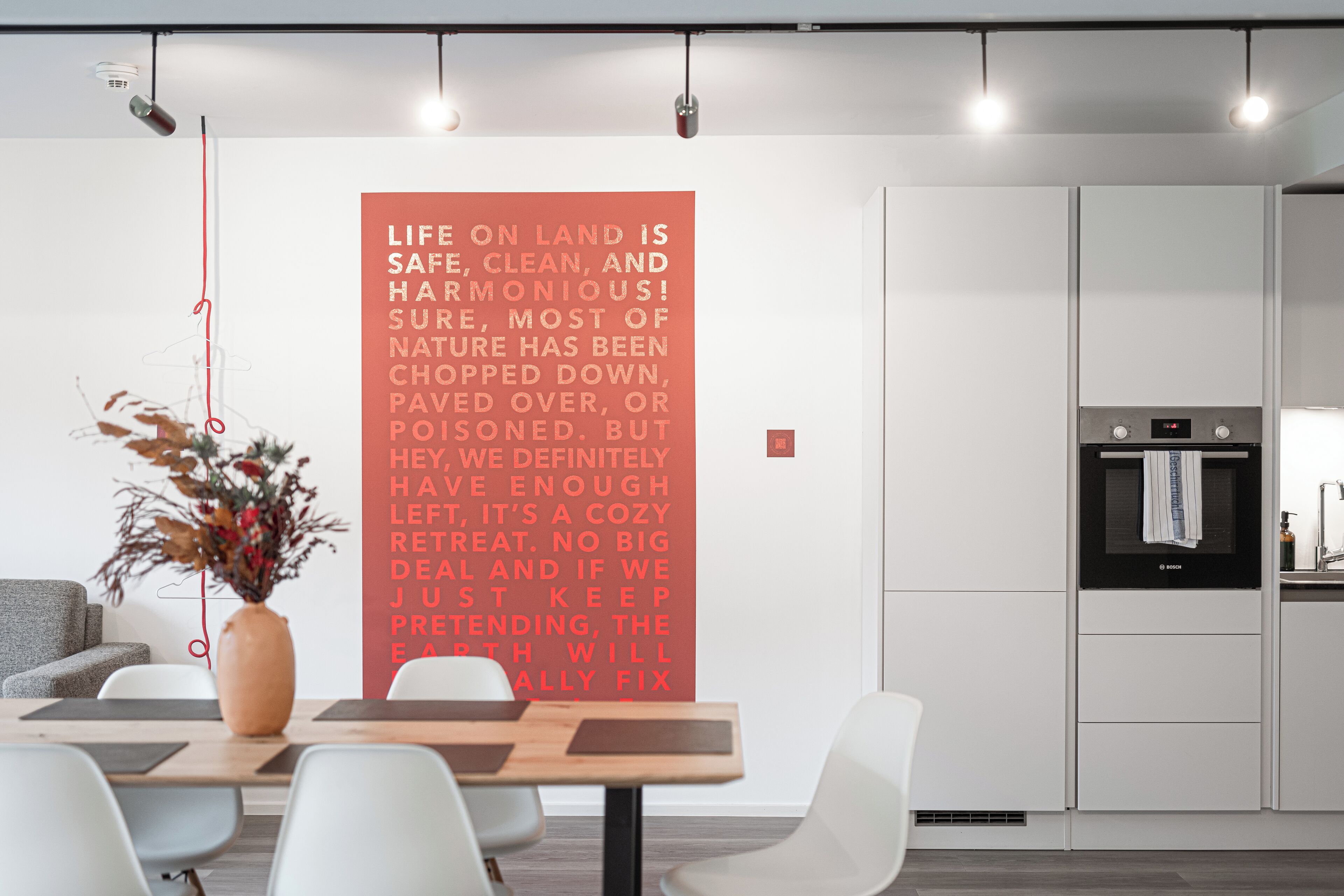 Une cuisine moderne avec des meubles blancs, un four Bosch et un évier.