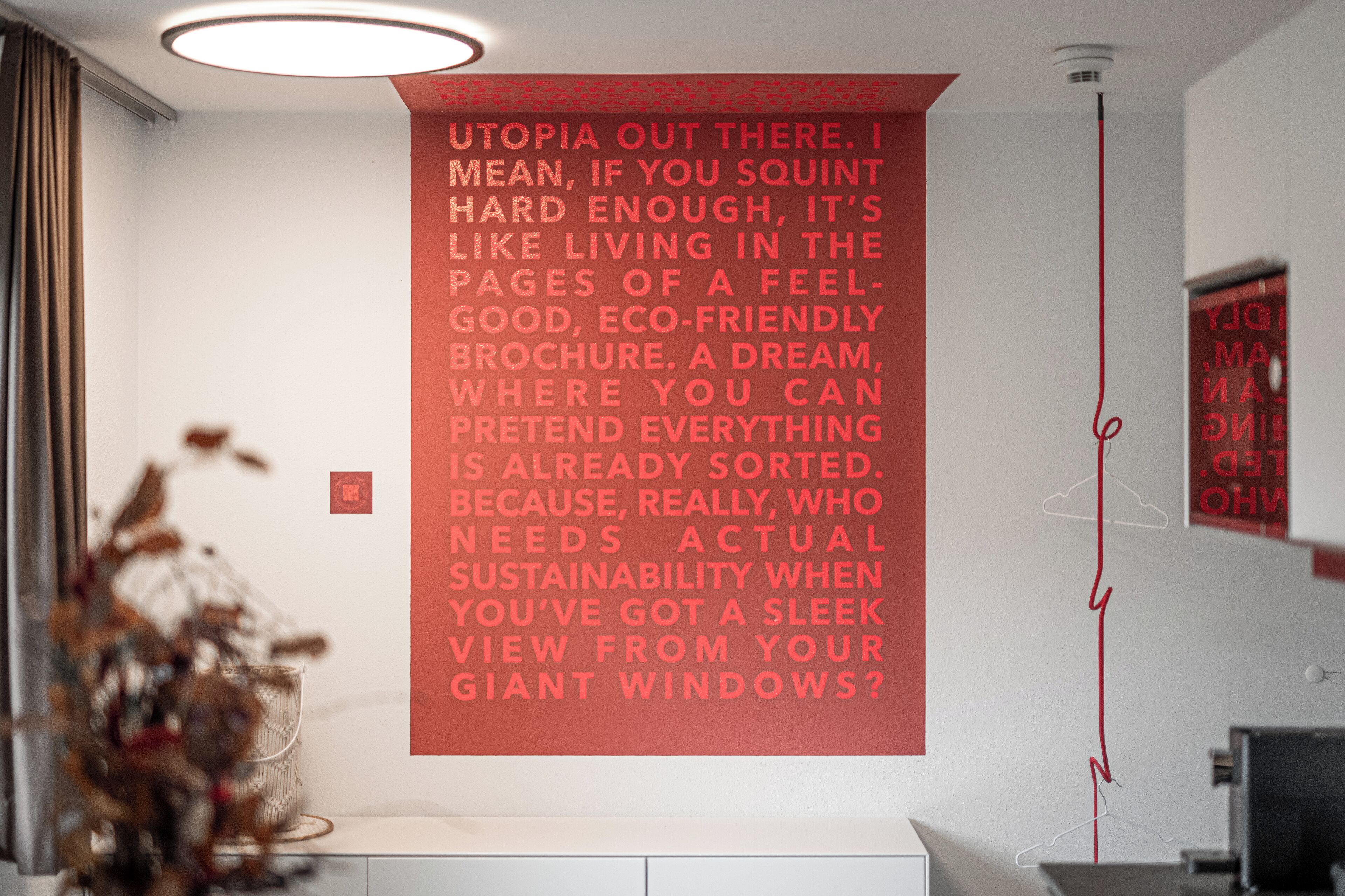 A room with a large poster on the wall, a desk, and a chair.