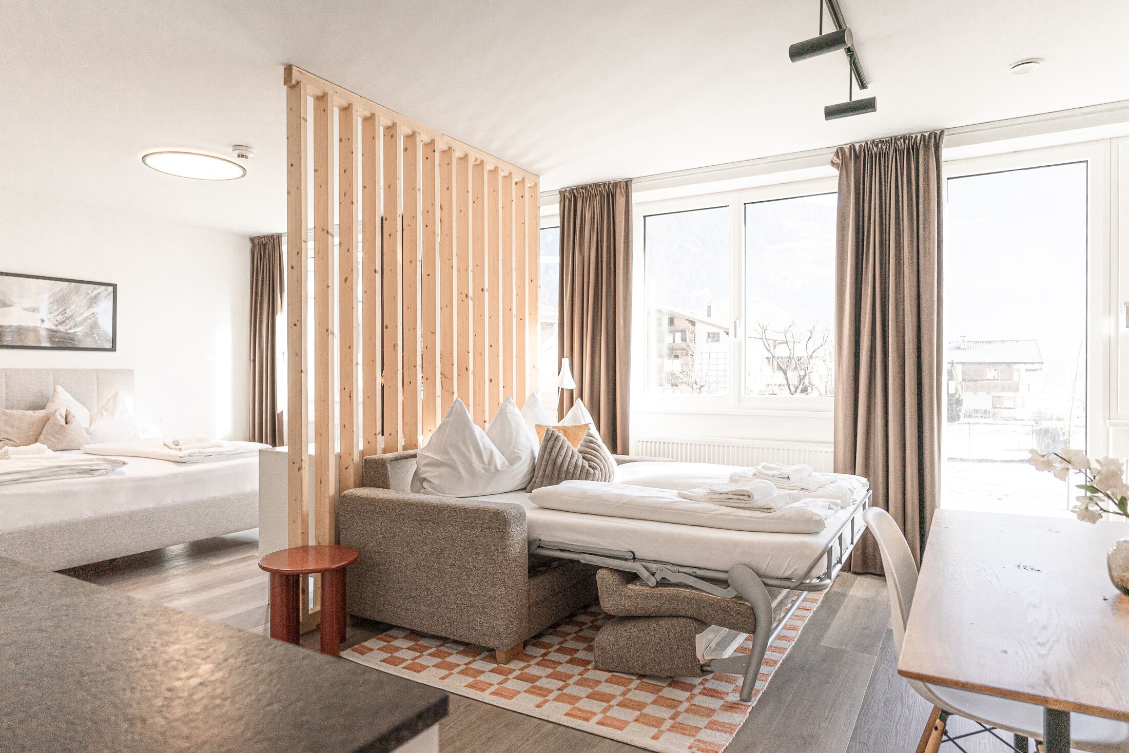 Une chambre d’hôtel moderne équipée d’un lit, d’un canapé et d’une table à manger.