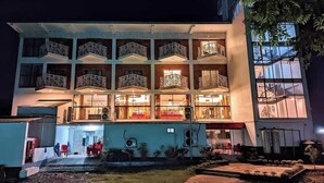 A multi-story hotel with balconies and a well-lit entrance. - Shada Pathor Hotel & Resort Sylhet  (Companiganj)