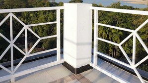 A balcony with a white railing overlooking a coastal landscape with trees and mountains in the distance. - Shada Pathor Hotel & Resort Sylhet  (Companiganj)