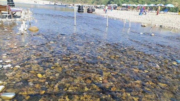 A beach with clear shallow water, rocks, and a sandy shore. - Shada Pathor Hotel & Resort Sylhet  (Companiganj)