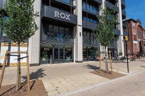 Um edifício moderno com a sinalização 'ROX', com fachada de vidro e revestimento de tijolos.