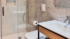 A modern bathroom with a glass-enclosed shower, a white toilet, and a vanity with a mirror. - HoneyComb GuestHouse (Rome)