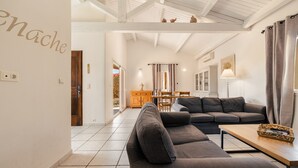 Una sala moderna con un sofá, una mesa de centro de madera y un comedor con una mesa y sillas.