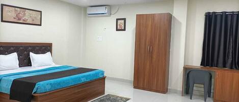A bedroom with a bed, wardrobe, desk, and ceiling fan.