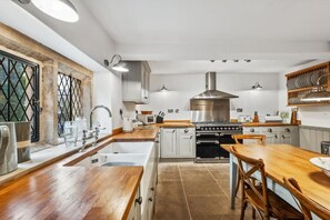 Een moderne keuken met een centraal eiland, roestvrijstalen apparatuur en houten keukenkastjes.