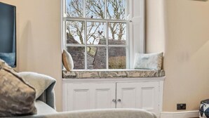 A room with a large window, a white cabinet, and a painting on the wall. - Host & Stay | Ivy Farm House - Wetton (Ashbourne)