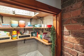 Cozy corner with a wooden shelf unit, labeled storage boxes, and a personal touch.