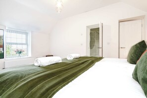 Une chambre à coucher avec un lit, une fenêtre, une porte et un radiateur.