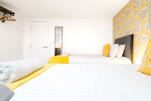 Une chambre d’hôtel comprenant un lit, une table de chevet, un miroir et une armoire.