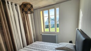 A bedroom with a bed, curtains, a window, and a hanging light fixture. - Villa with pool near Uzès (Saint-Laurent-la-Vernède)