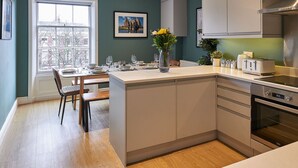 Een moderne keuken met een centraal eiland, een eetgedeelte met uitzicht en een groot raam.