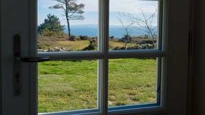 A window with a view of a grassy landscape and a tree. - Villa ile vierge-Crozon Nature, sea, listed site (Crozon)