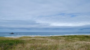 A coastal landscape with a grassy foreground, a sandy beach, and the ocean under a cloudy sky. - Villa ile vierge-Crozon Nature, sea, listed site (Crozon)