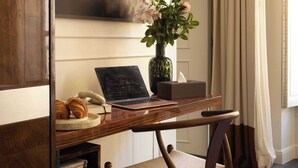 A wooden desk with a laptop, a vase with flowers, and a pair of croissants. - Hôtel Palais Bourbon (Paris)
