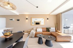A modern living space with a sofa, a dining table, and a coffee table.