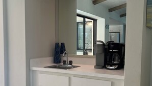 A bathroom with a white vanity, a sink, a mirror, and a coffee maker. - Palms and Paradise 3-bedroom 2-bath house with heated pool in serene Cape Coral. (Cape Coral)