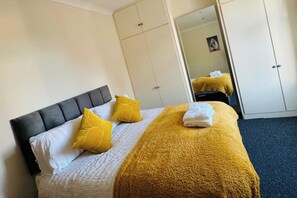 A hotel room with a bed, a wardrobe, and a mirror. - 2 Bedroom House - Sleeps 4 - Free Parking, Wifi (Leicester)