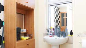 A bathroom with a wooden cabinet, a sink, and a mirror. - 2 Bedroom House - Sleeps 4 - Free Parking, Wifi (Leicester)