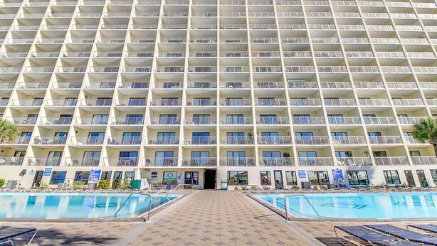 A large hotel with multiple balconies and a central entrance.