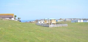 Stroll through a charming coastal neighborhood with houses of varying sizes and a fenced playground featuring a slide and climbing structures.