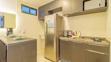 Una cocina moderna con electrodomésticos de acero inoxidable, encimera de granito y horno empotrado.