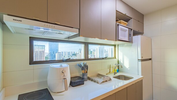 A modern kitchen with a built-in stove, a microwave, and a refrigerator.