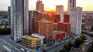 A high-rise urban area with modern buildings, a busy intersection, and a sunset in the background.
