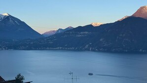 Un lac avec des montagnes en arrière-plan et un bateau sur l’eau.