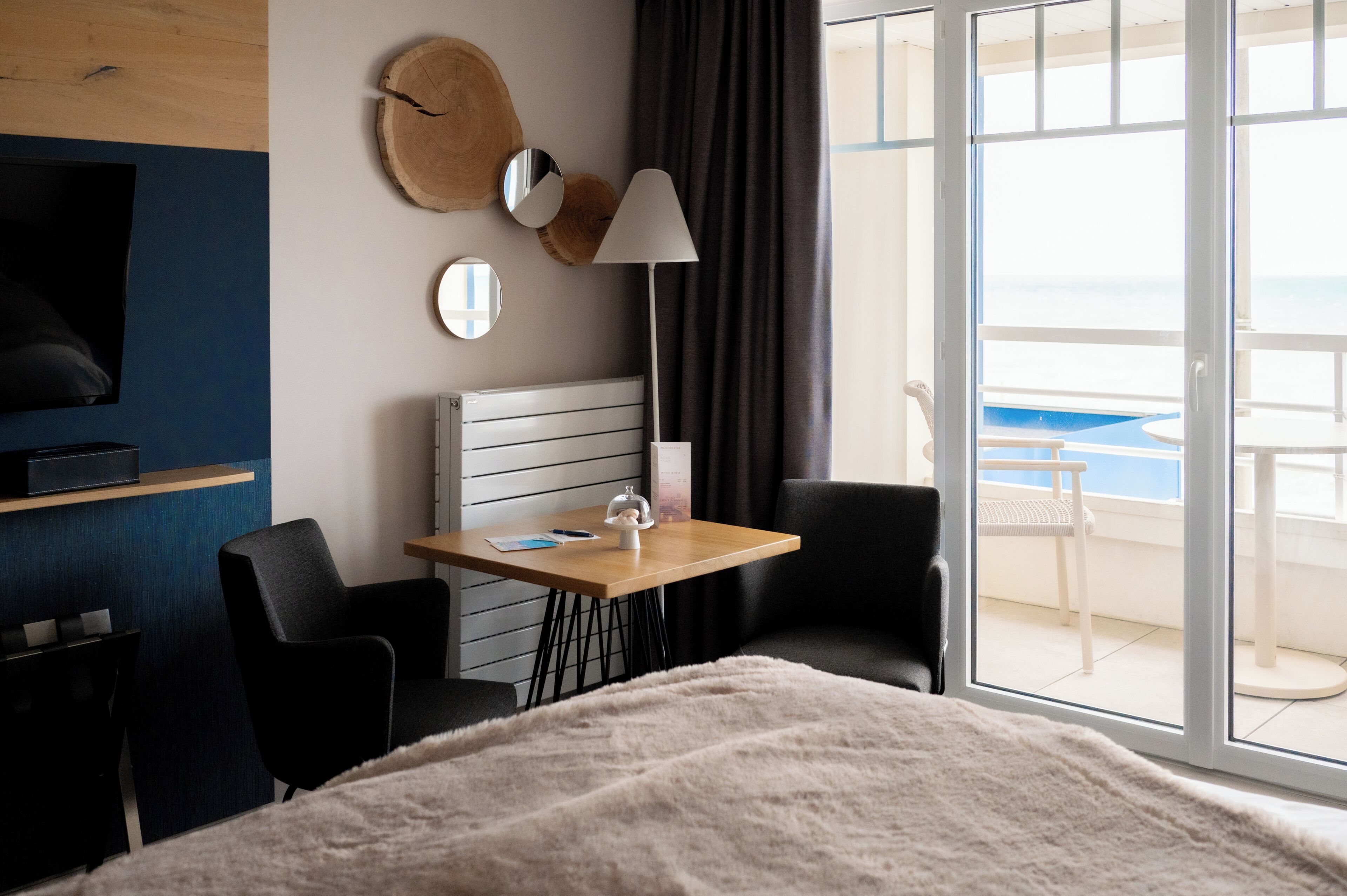 Une chambre d’hôtel équipée d’un lit, d’un bureau, d’une chaise, d’une télévision, d’une lampe, avec vue sur la piscine et un balcon.