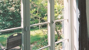 Une pièce dotée d’une porte-fenêtre coulissante donnant sur un jardin.