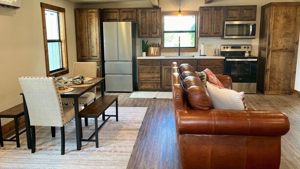 Una cocina moderna con armarios de madera, un refrigerador de acero inoxidable y un microondas.