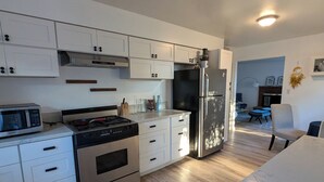 Una cocina moderna con armarios blancos, electrodomésticos de acero inoxidable y encimera de mármol.