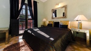 A bedroom with a large bed, two bedside tables, a mirror, and a window with curtains. - Residence Dar Lamia Marrakech : 1 Bedroom Villa  (Dar Caïd Layadi)