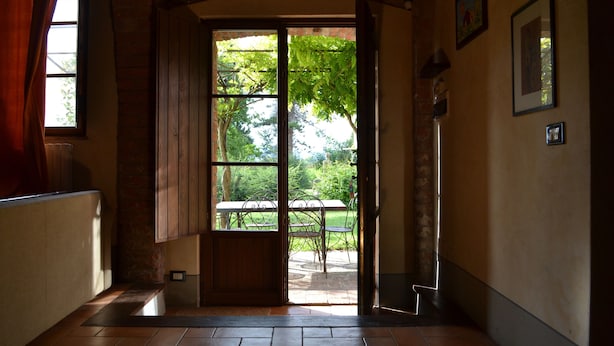 An open door leading to an outdoor patio with a table and chairs. - Appartamento Vele, Wifi, Near Perugia (Monteleone d'Orvieto)