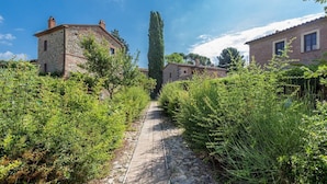 A stone pathway leading to traditional stone buildings surrounded by lush greenery. - Appartamento Vele, Wifi, Near Perugia (Monteleone d'Orvieto)