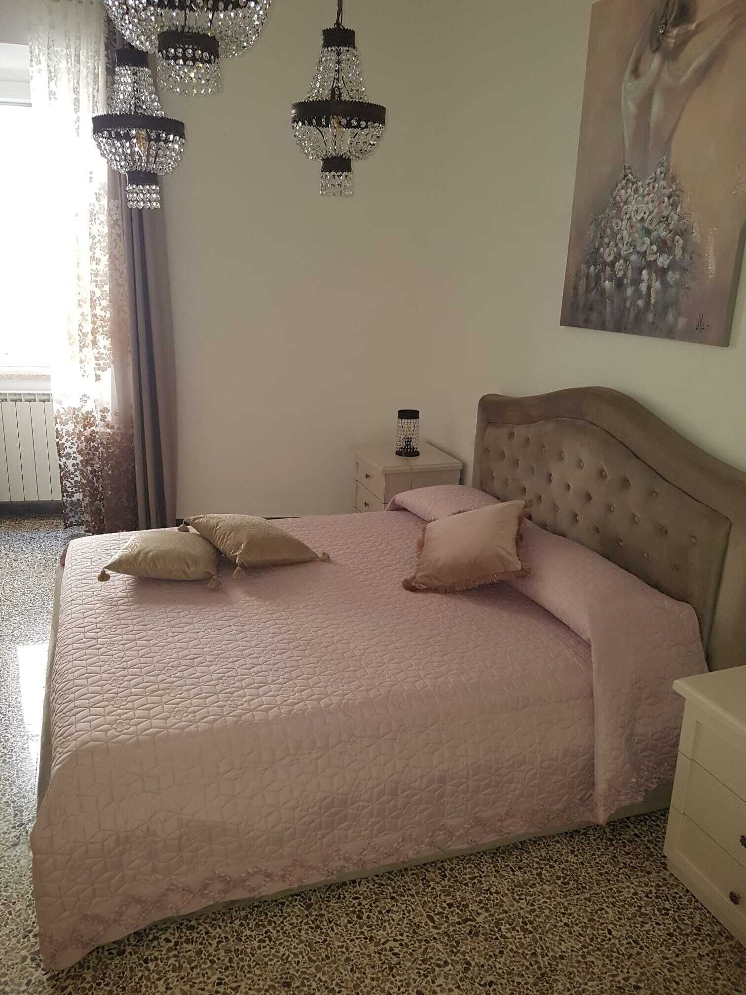 Une chambre à coucher avec un lit, une table de chevet, une lampe et un tableau au mur.