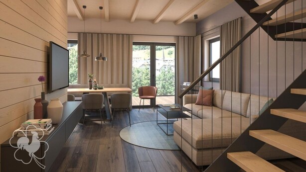 A modern living room with a sofa, coffee table, and a TV mounted on the wall. There is a staircase leading to an upper level. - Modernes Chalet in Hahnenklee (Goslar)