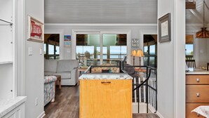 Un salon chaleureux avec un canapé, un meuble en bois et un coin repas comprenant une table et des chaises.