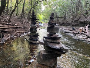 A natural setting with a clear stream and two stone stacks. - Mermaid Hotel Amazon  (Presidente Figueiredo)