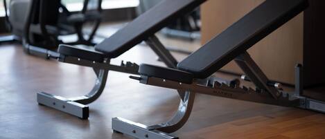 A gym with exercise equipment, including a bench and a treadmill.