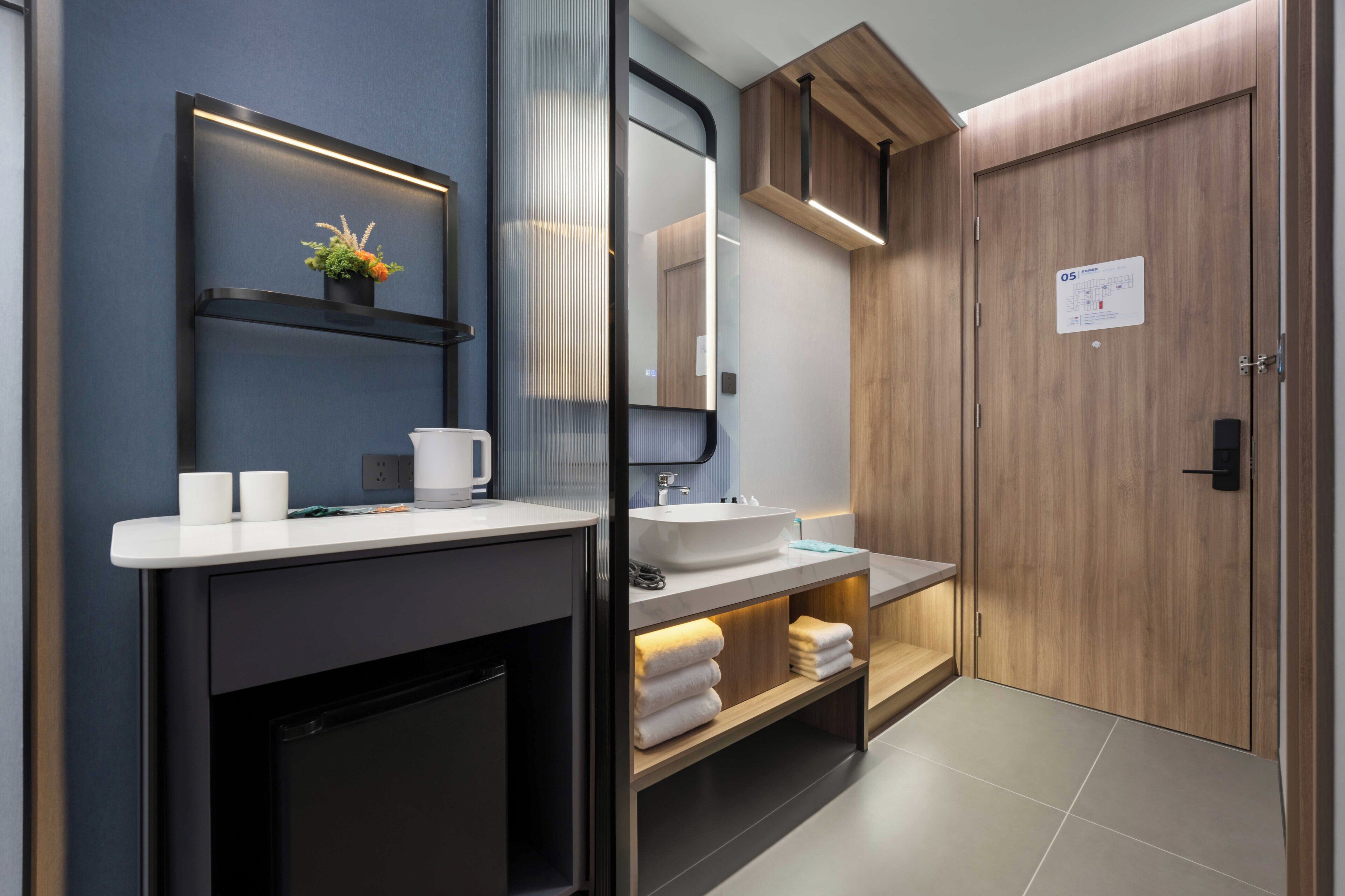 A modern bathroom with a large mirror, a sink, a toilet, and a cabinet.