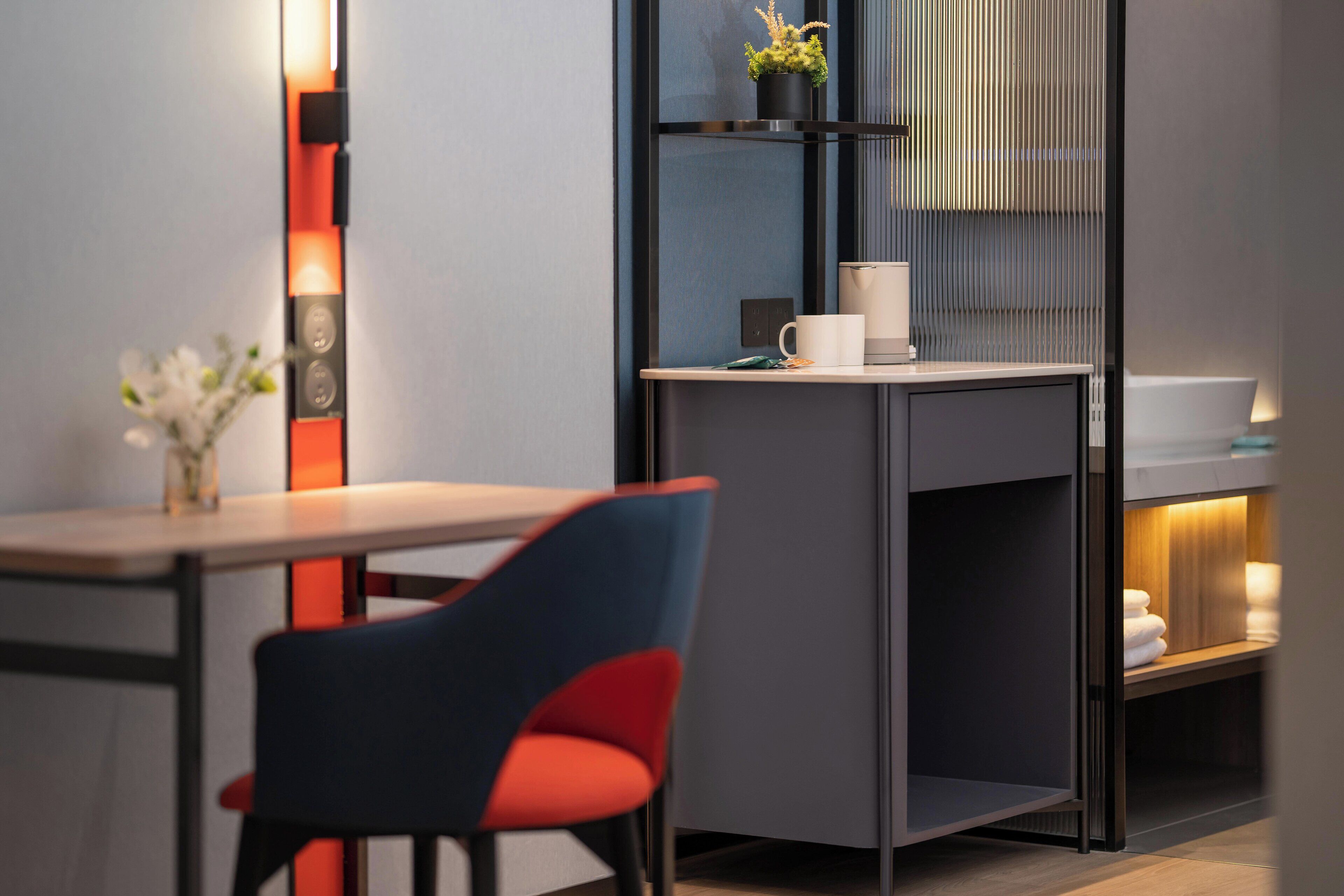 A modern kitchen with a built-in stove, a coffee machine, and a small plant on the countertop.