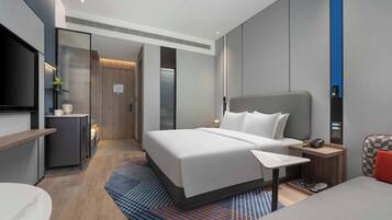 Een moderne hotelkamer met een groot bed, nachtkastje en een televisie.