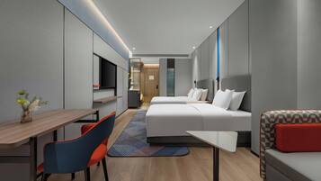 Ein modernes Hotelzimmer mit Bett, Sofa, Schreibtisch und Fernseher.