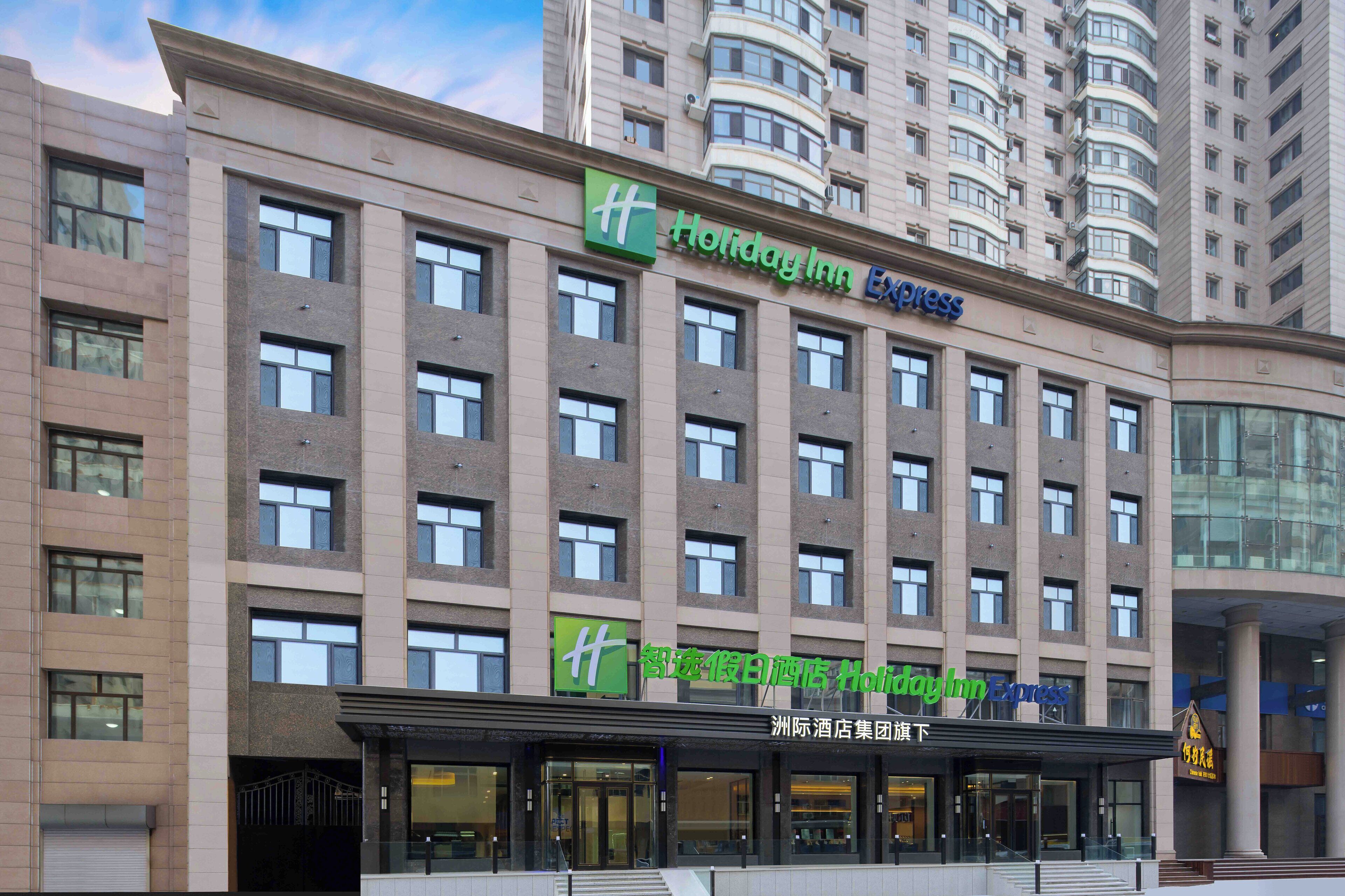 A Holiday Inn Express building with a modern facade, multiple windows, and a prominent signage.